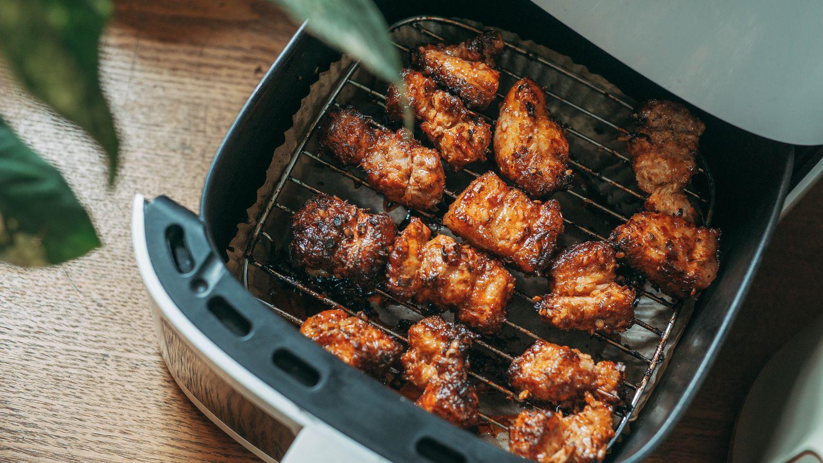 Alitas de pollo doradas dentro de una freidora de aire