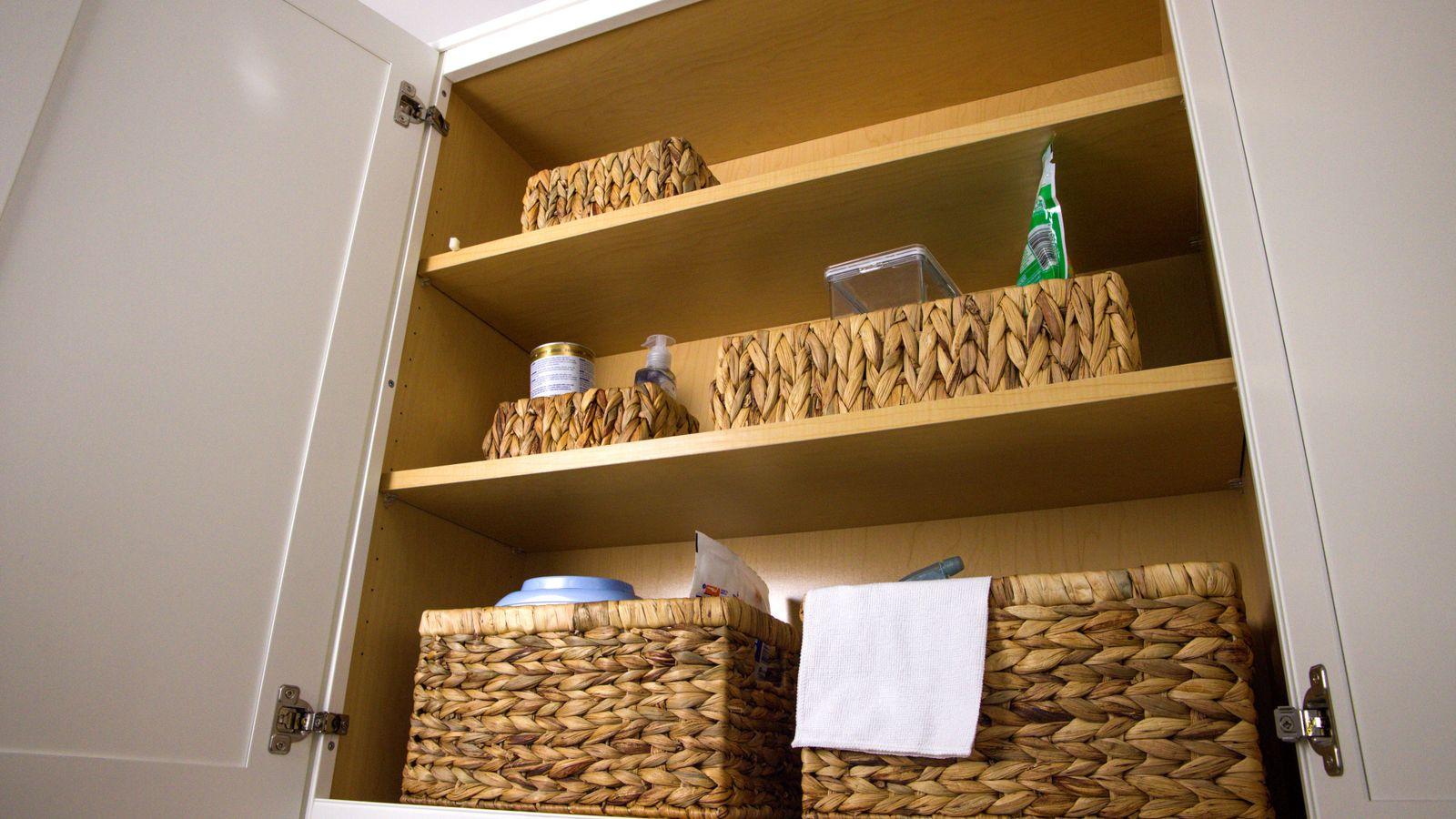 Armario de cocina abierto con cestas de mimbre y baldas de madera