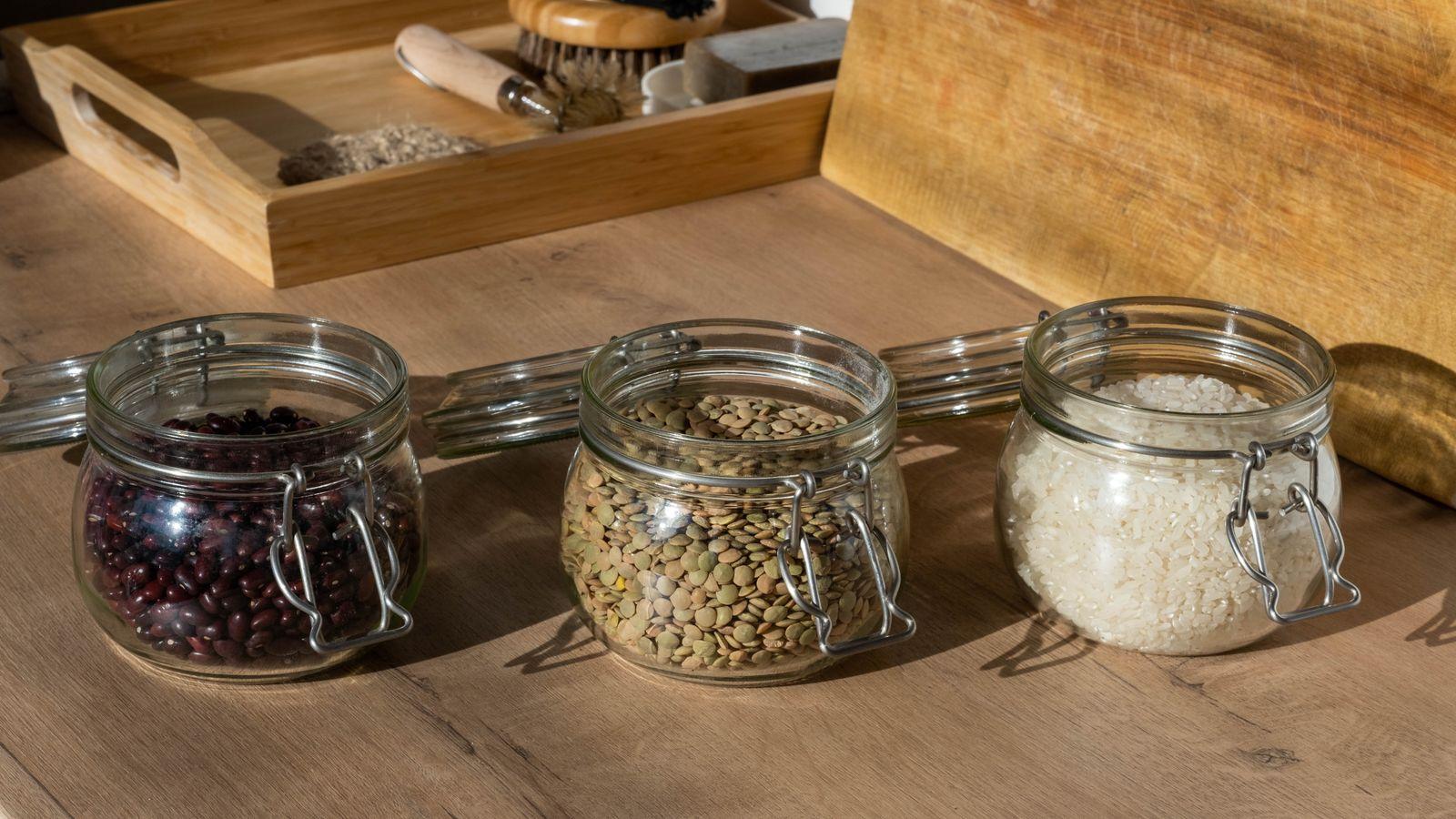 Tarros de cristal con legumbres sobre una mesa de madera