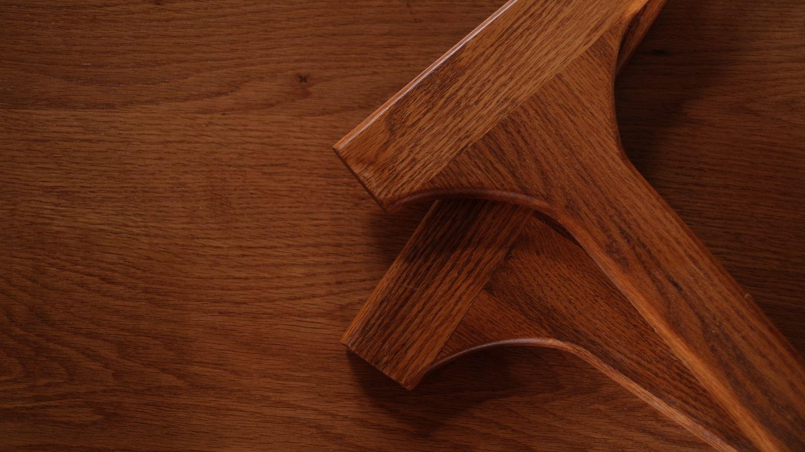 Detalle de patas de madera barnizada sobre una superficie de roble