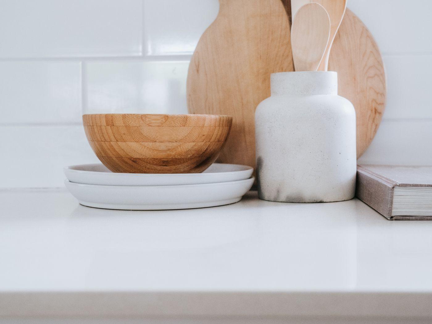 Encimera con tabla de madera, cuenco y tarros de cerámica